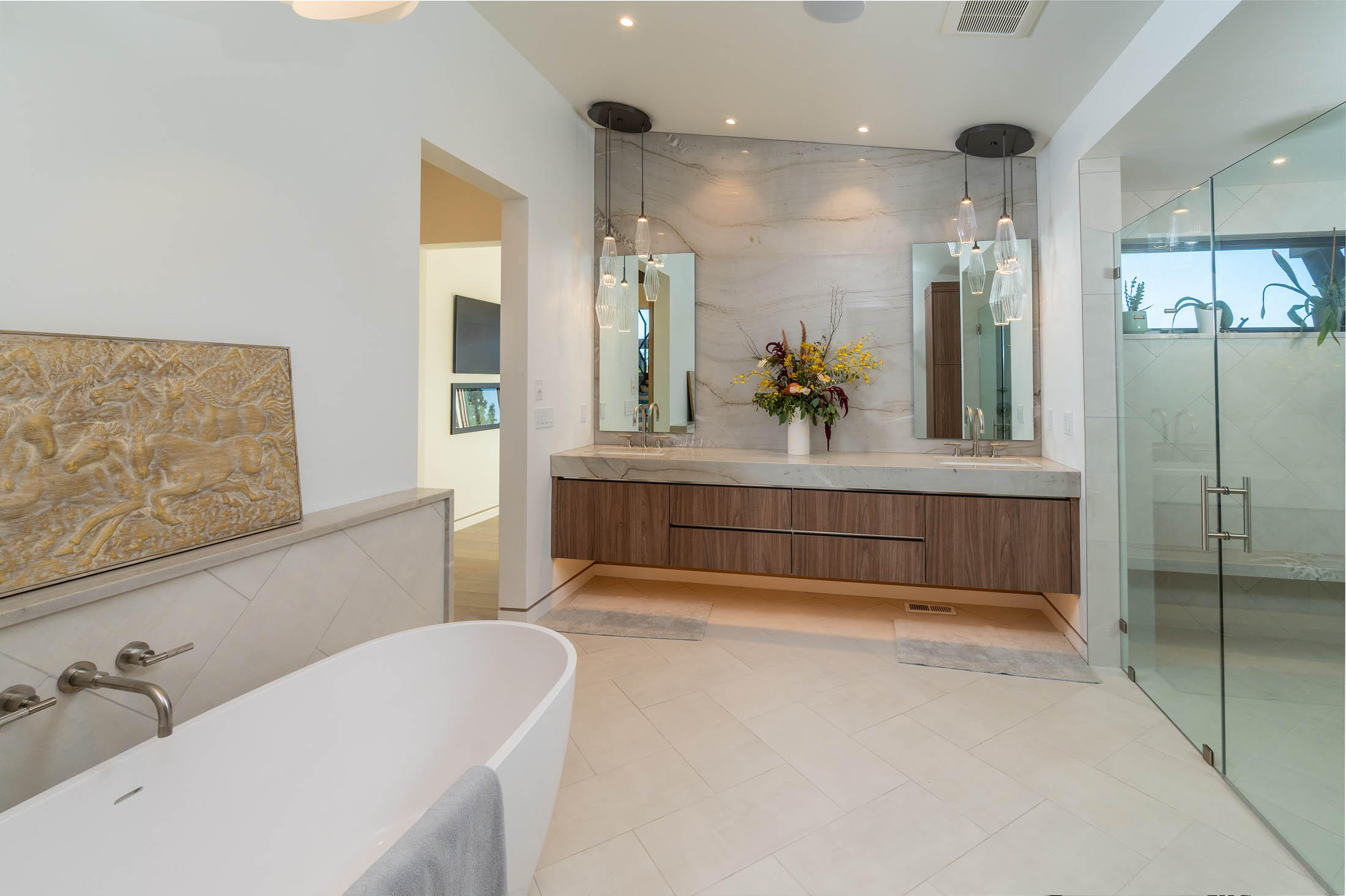 Primary bath with a freestanding tub, floating vanity, and glass shower