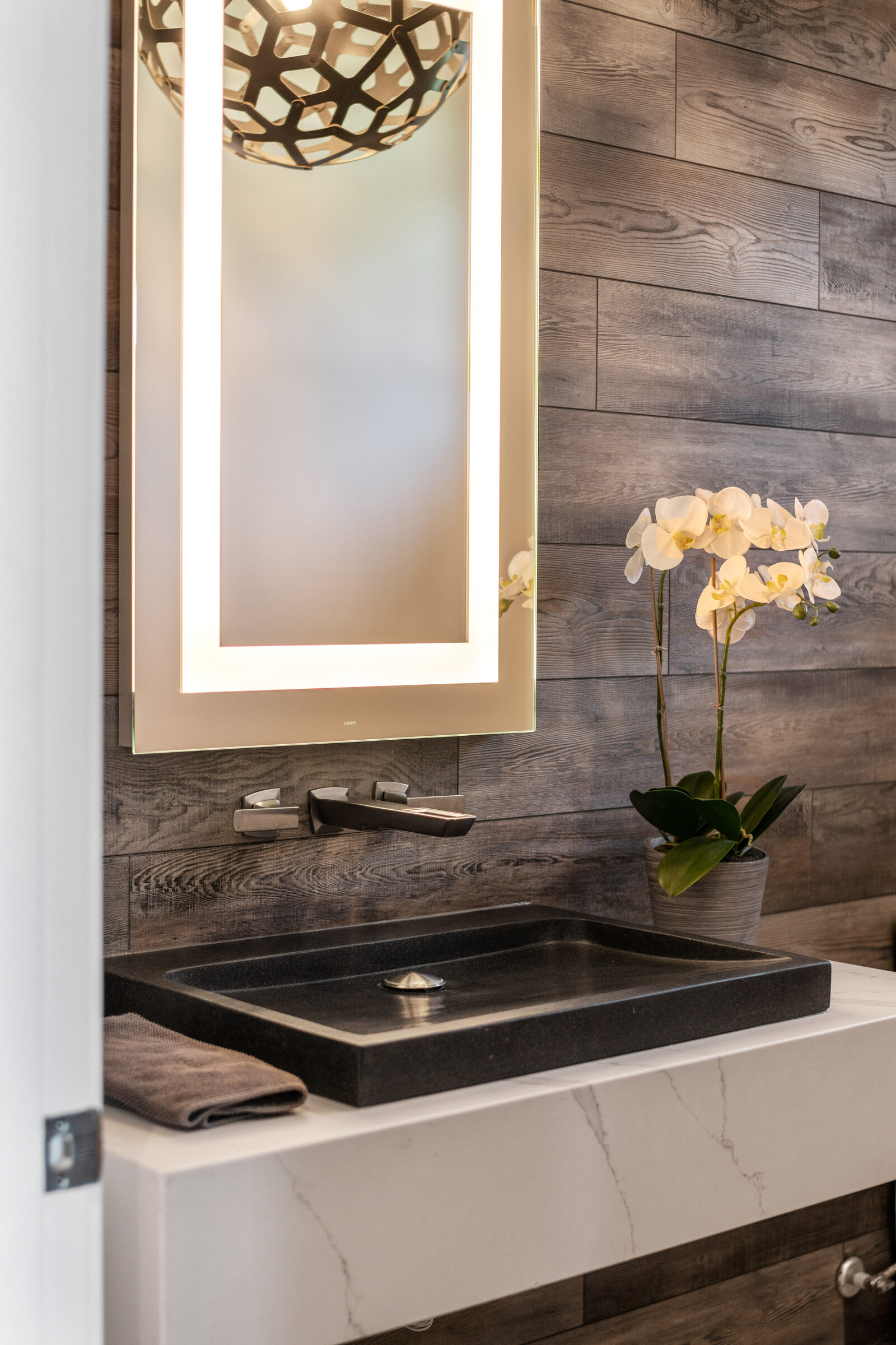 Powder room with a reclaimed-wood wall and stone vessel sink