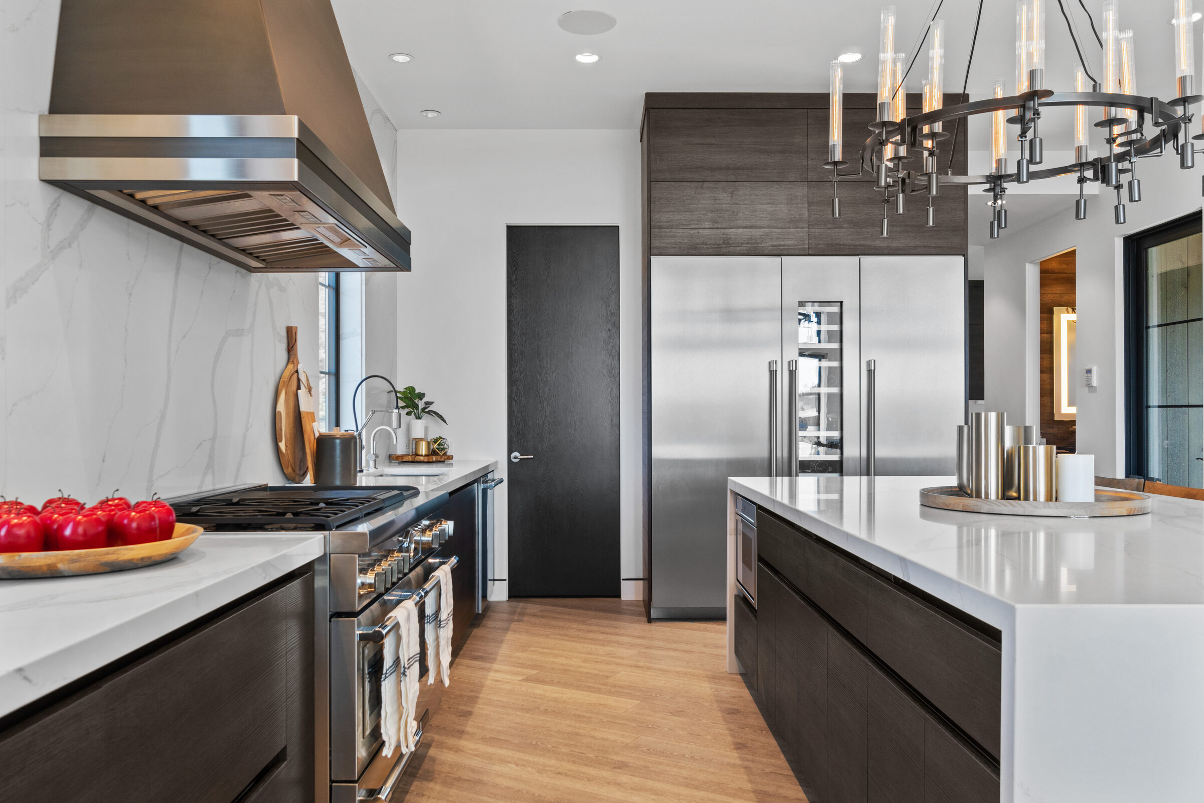 Kitchen with a marble waterfall island and professional range