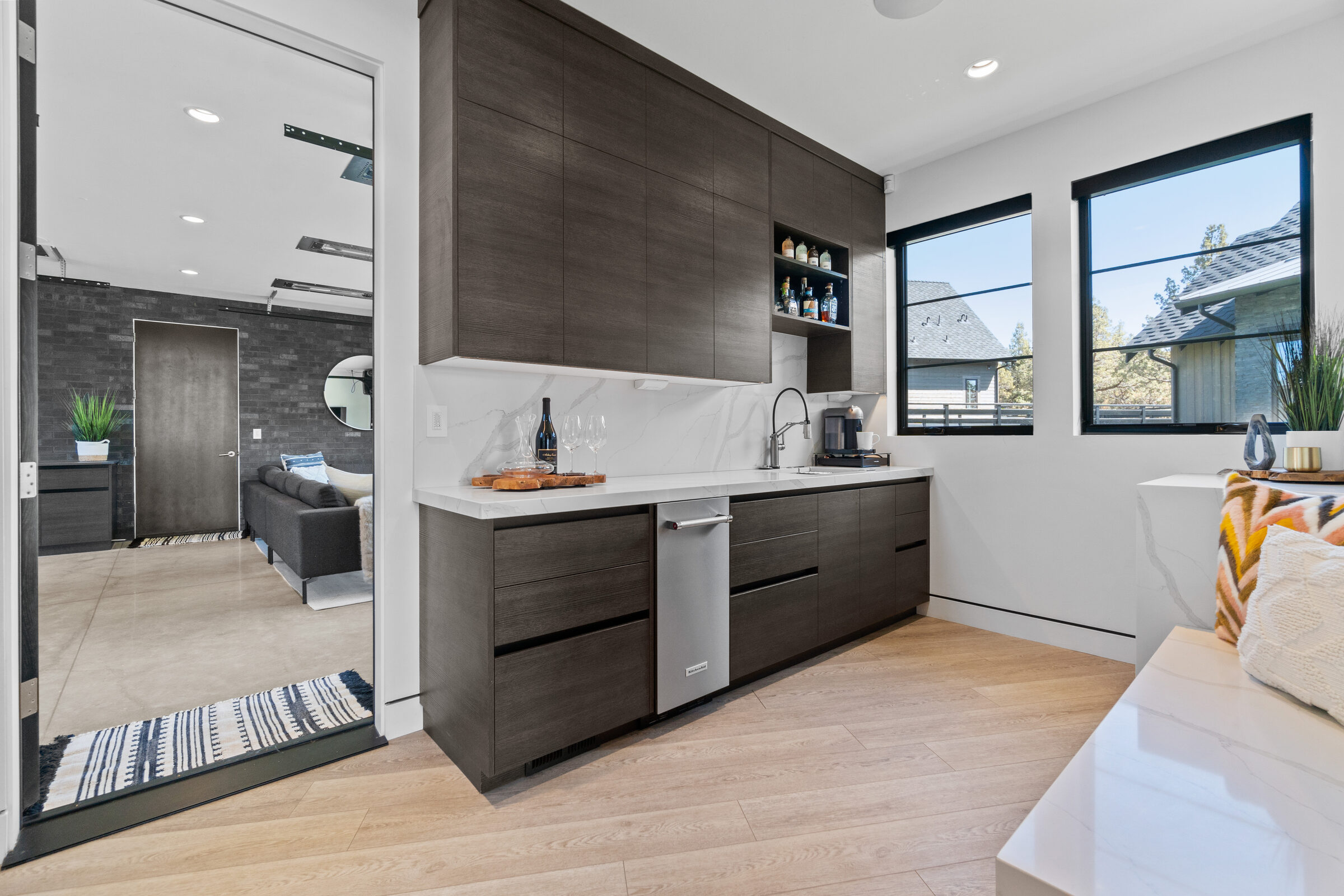 Wet bar with dark cabinetry, a bar sink, and integrated wine storage