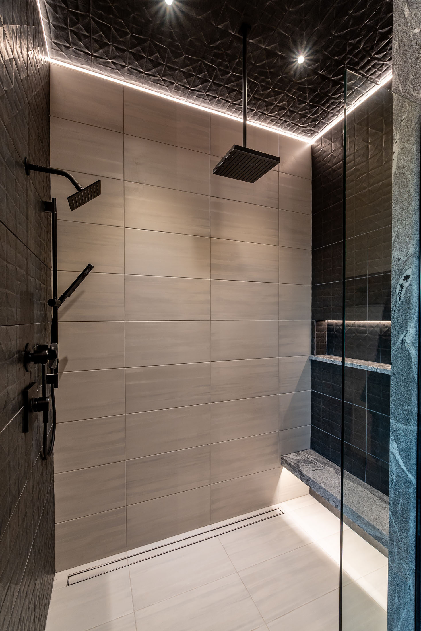 Walk-in shower with large-format tile and black rain-head fixtures