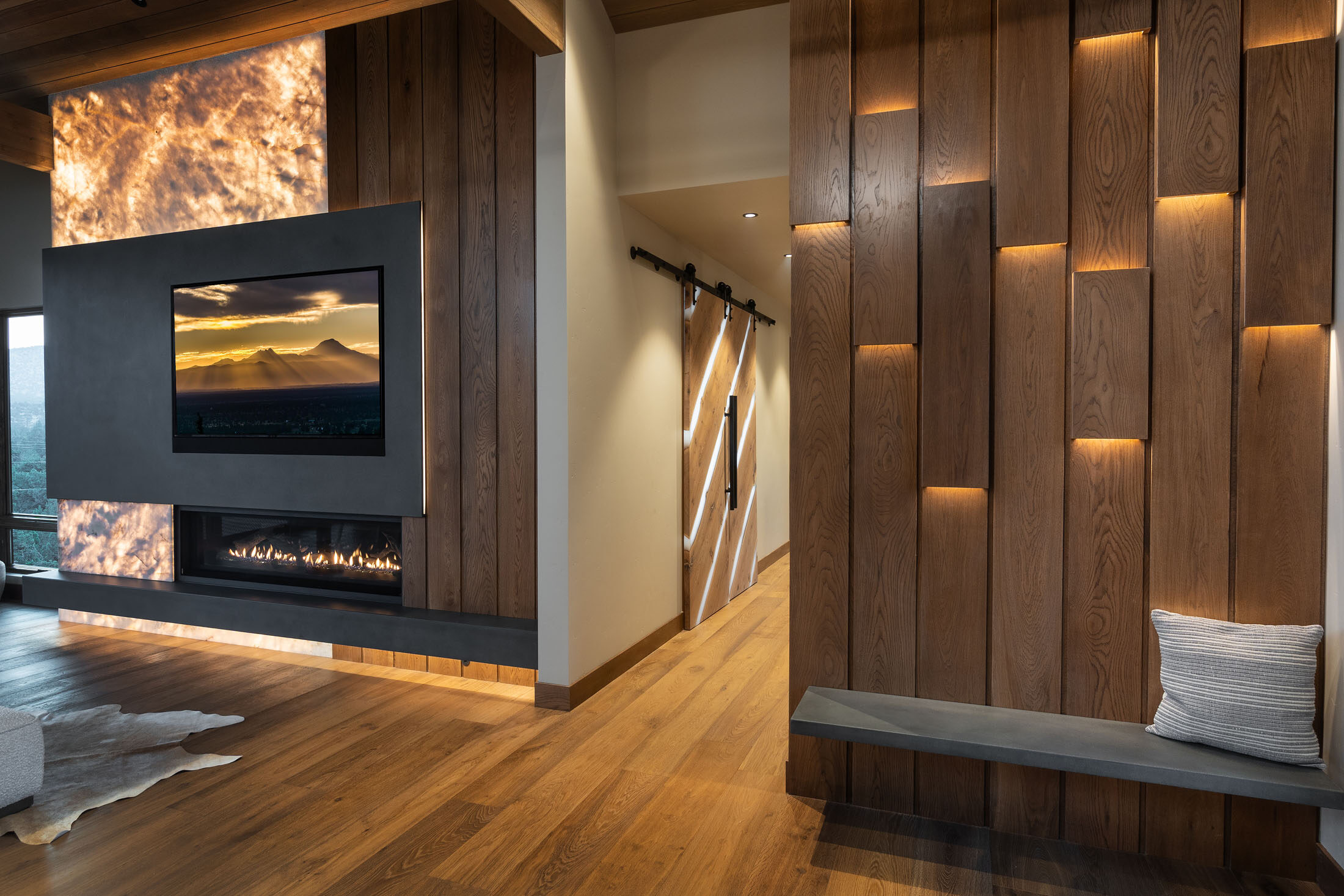 Great room with an onyx fireplace, vertical wood-slat wall, and sliding barn door