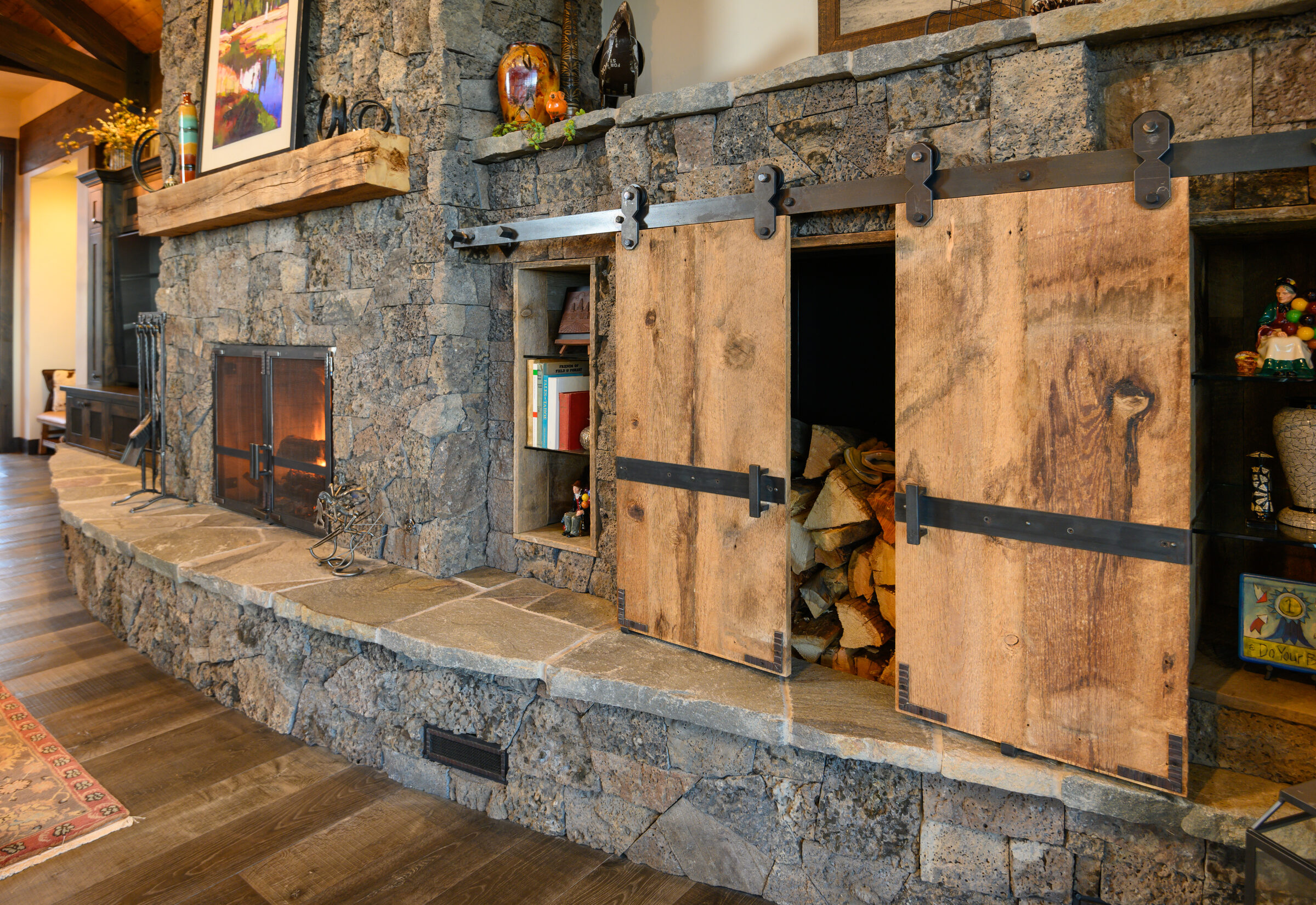 Great room hearth flanked by reclaimed-wood sliding barn doors