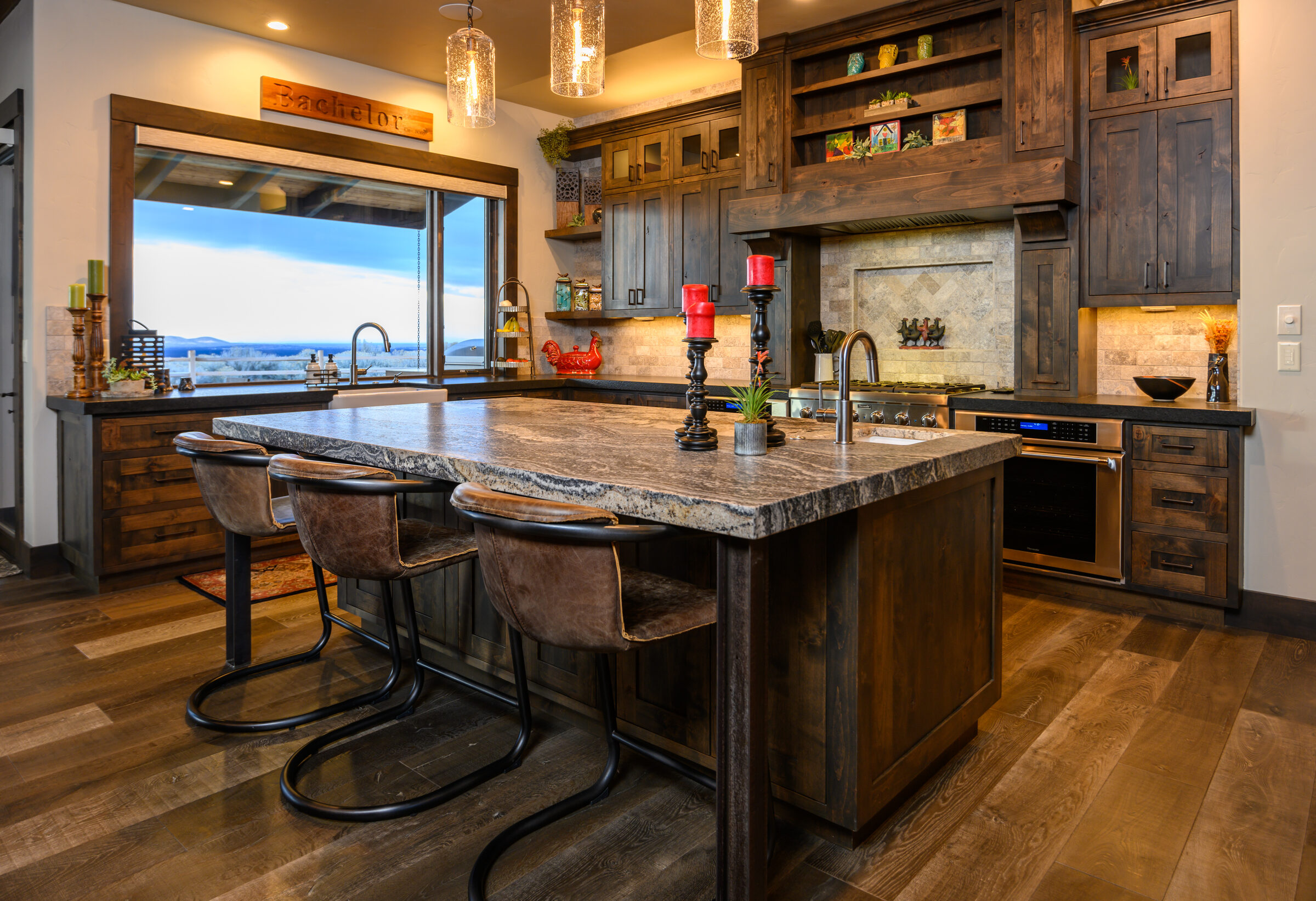 Kitchen with a stone-topped island and a picture window framing the high desert