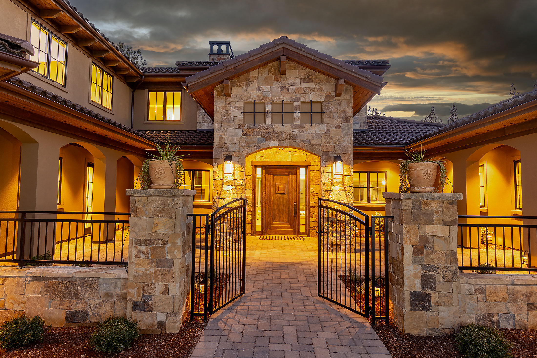 North Rim gated stone entry courtyard at dusk, Awbrey Butte, Bend