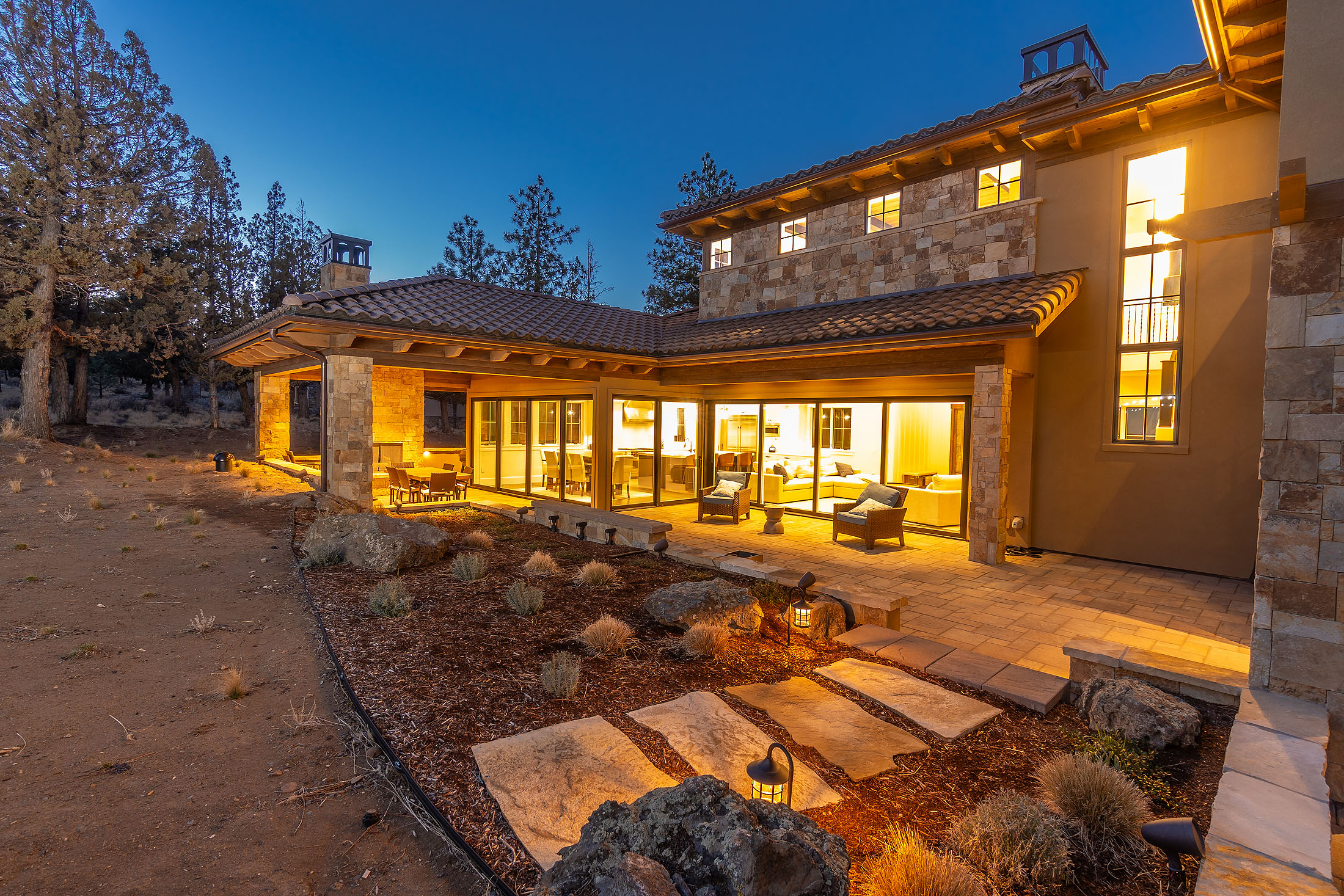 Rear patio and stone-paver terrace at dusk at the Sunrise North Rim residence, Awbrey Butte, Bend