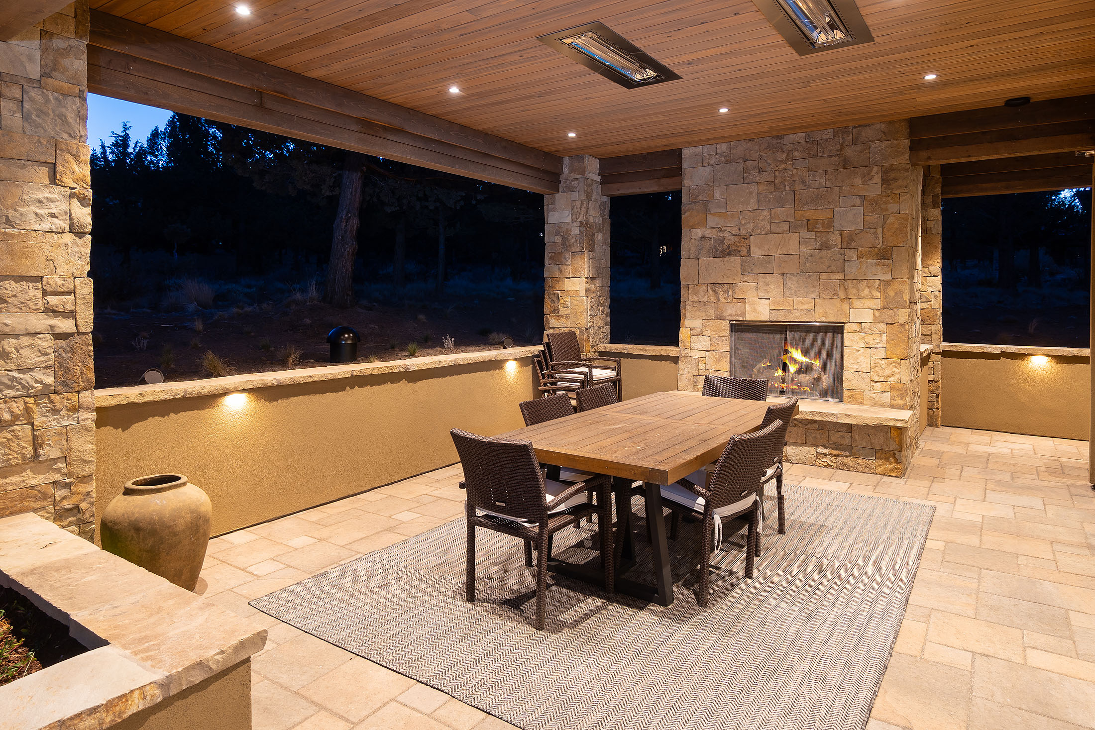 Covered outdoor room with stone fireplace at the Sunrise North Rim residence, Awbrey Butte, Bend
