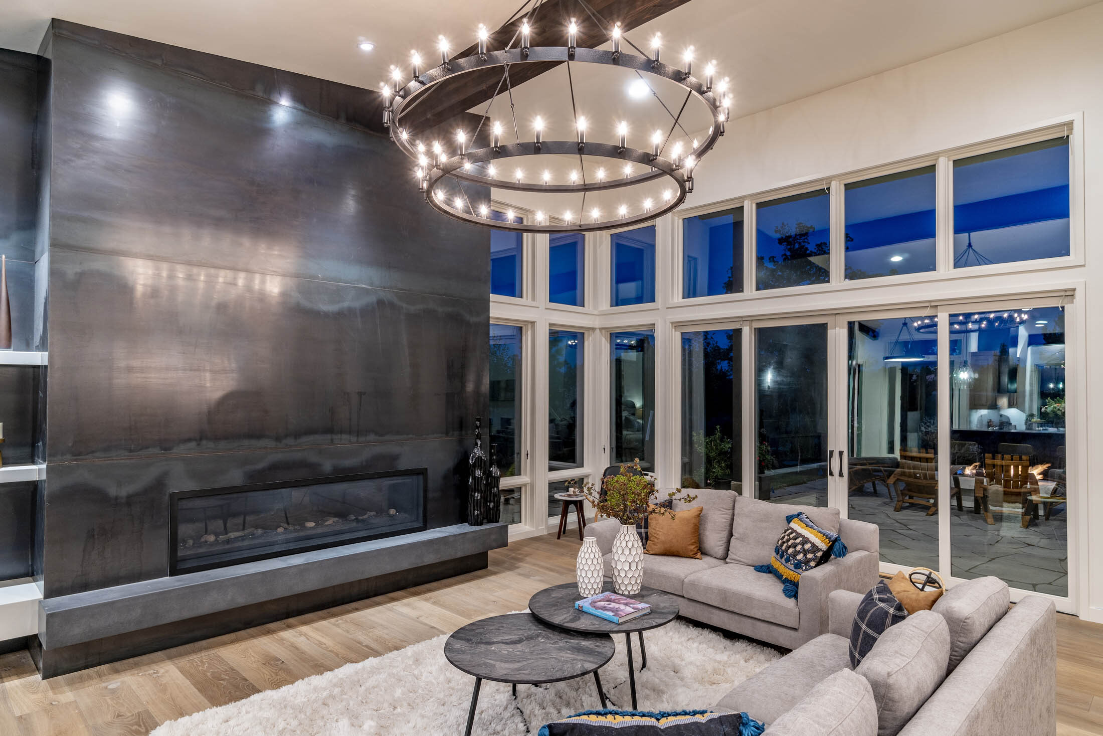 Great room anchored by a blackened-steel linear fireplace and walls of glass