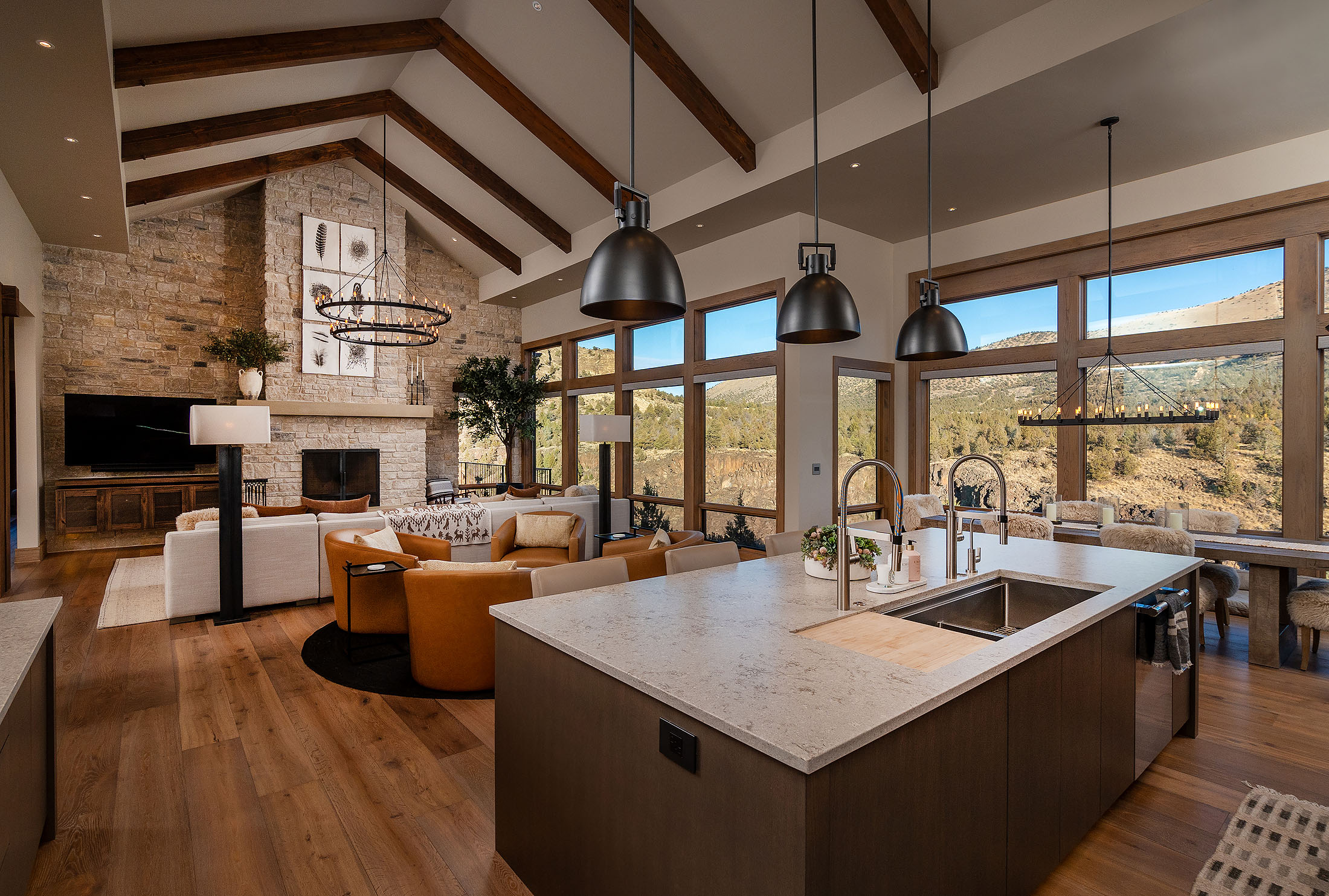 Great room with a stone fireplace and walls of glass at the Sunrise Cliff Side Ranch Estate, Ranch at the Canyons, Terrebonne