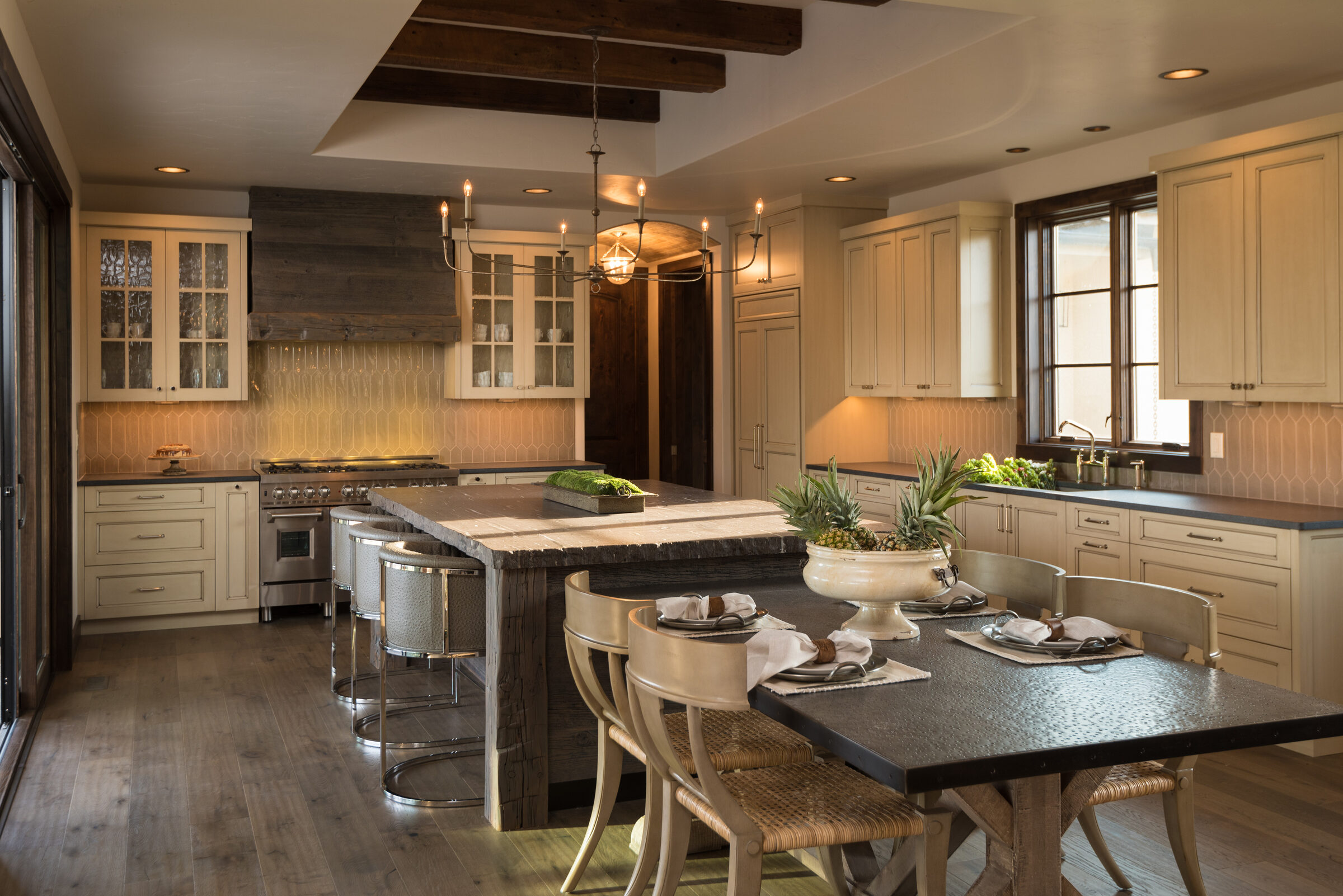 Kitchen with cream cabinetry, a stone range hood, and an island beneath a timber-beamed ceiling, Ranch at the Canyons