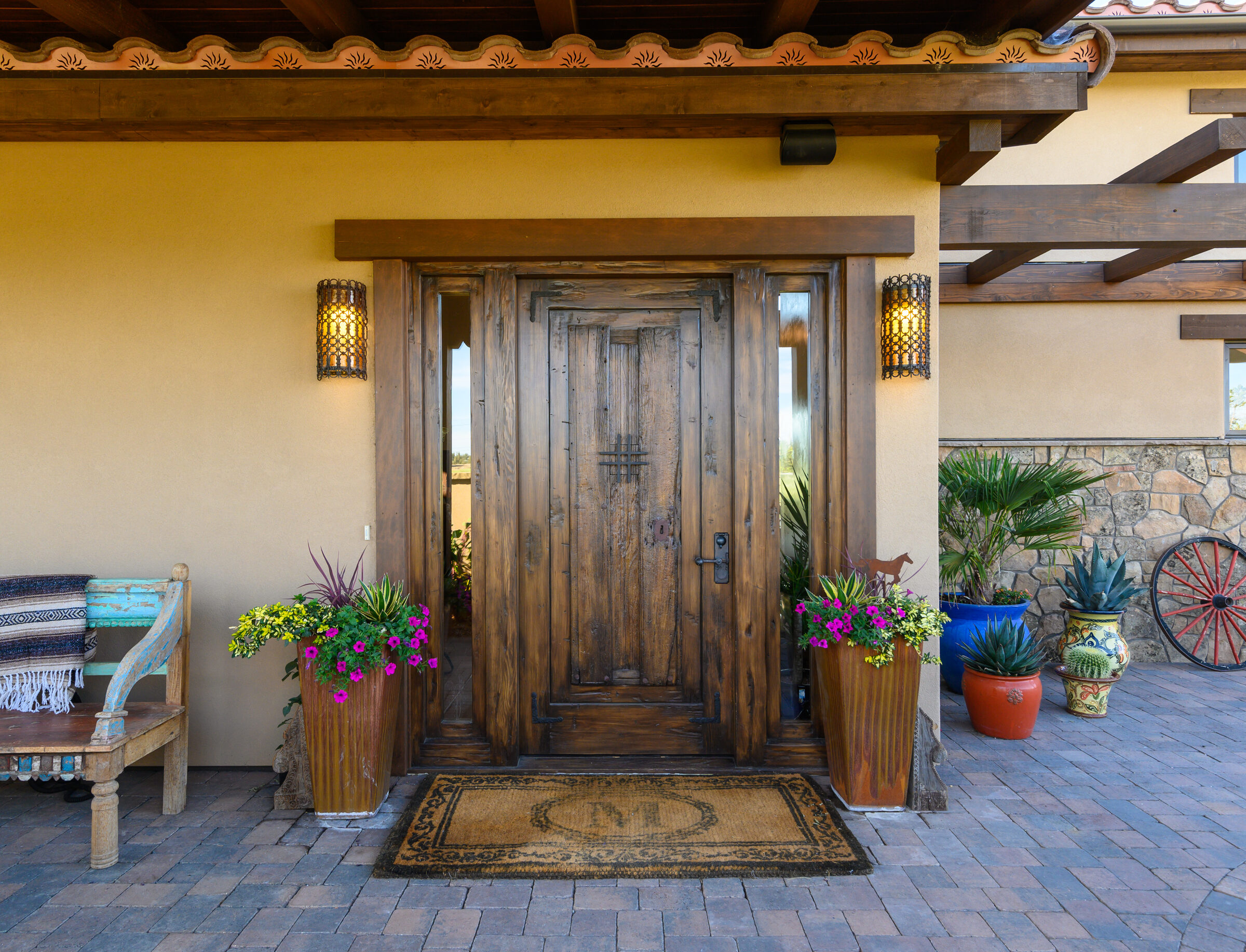 Carved double-door entry beneath a timber portico with a clay-tile roof
