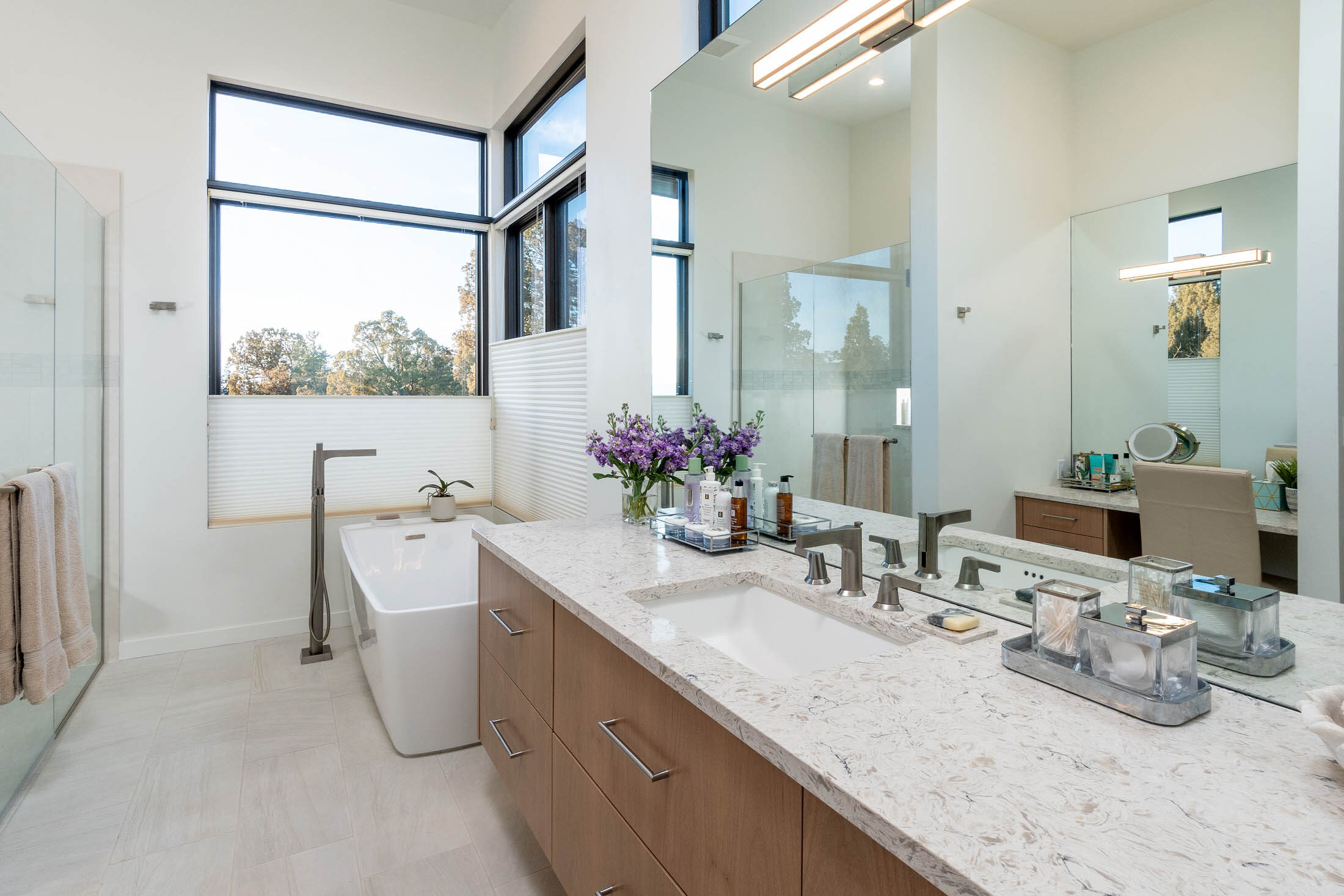 Starview primary bath with freestanding tub, marble-top vanity, and corner windows, Brasada Ranch